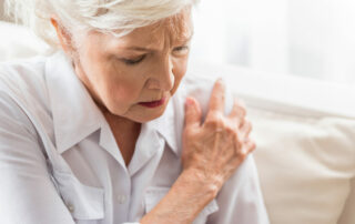 Senior woman holding shoulder, joint pain
