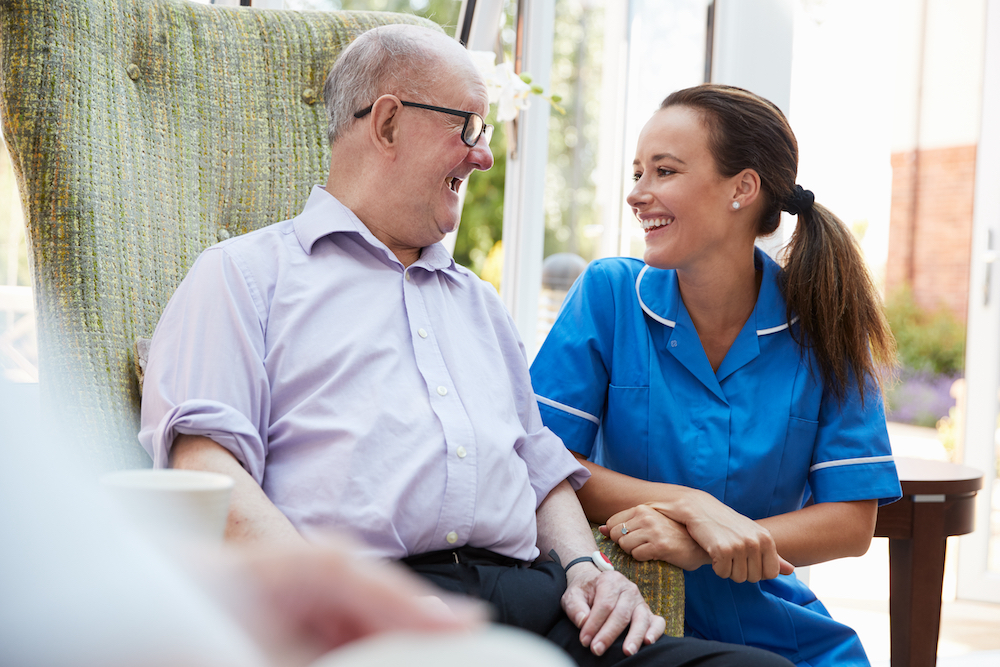 A senior man and a staff member visit together