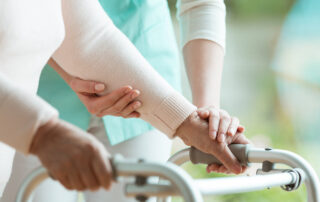 A nurse helping a senior woman with a walker