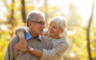 A smiling, happy couple going for a walk in the park near the retirement communities near me