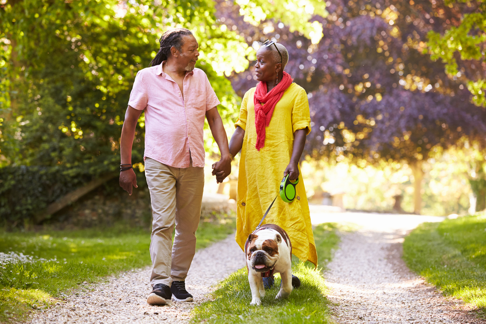couple walking their dog at senior living apartments macomb