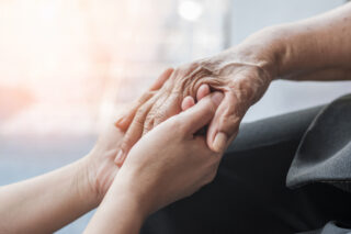 Senior holding hands in assisted living facilities near me.