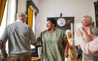 group of friends dancing inside and enjoying their senior living apartments macomb